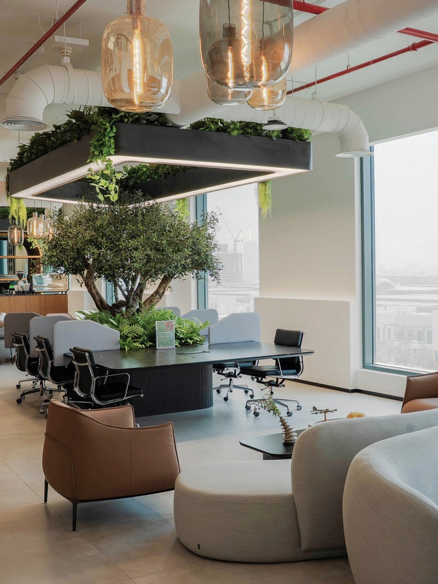 Lounge seating beneath the planting at flowork Dubai Hills, the city beyond