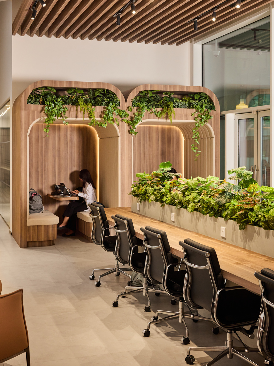 The long coworking bench at flowork Vision Tower, planting along its length and study alcoves behind