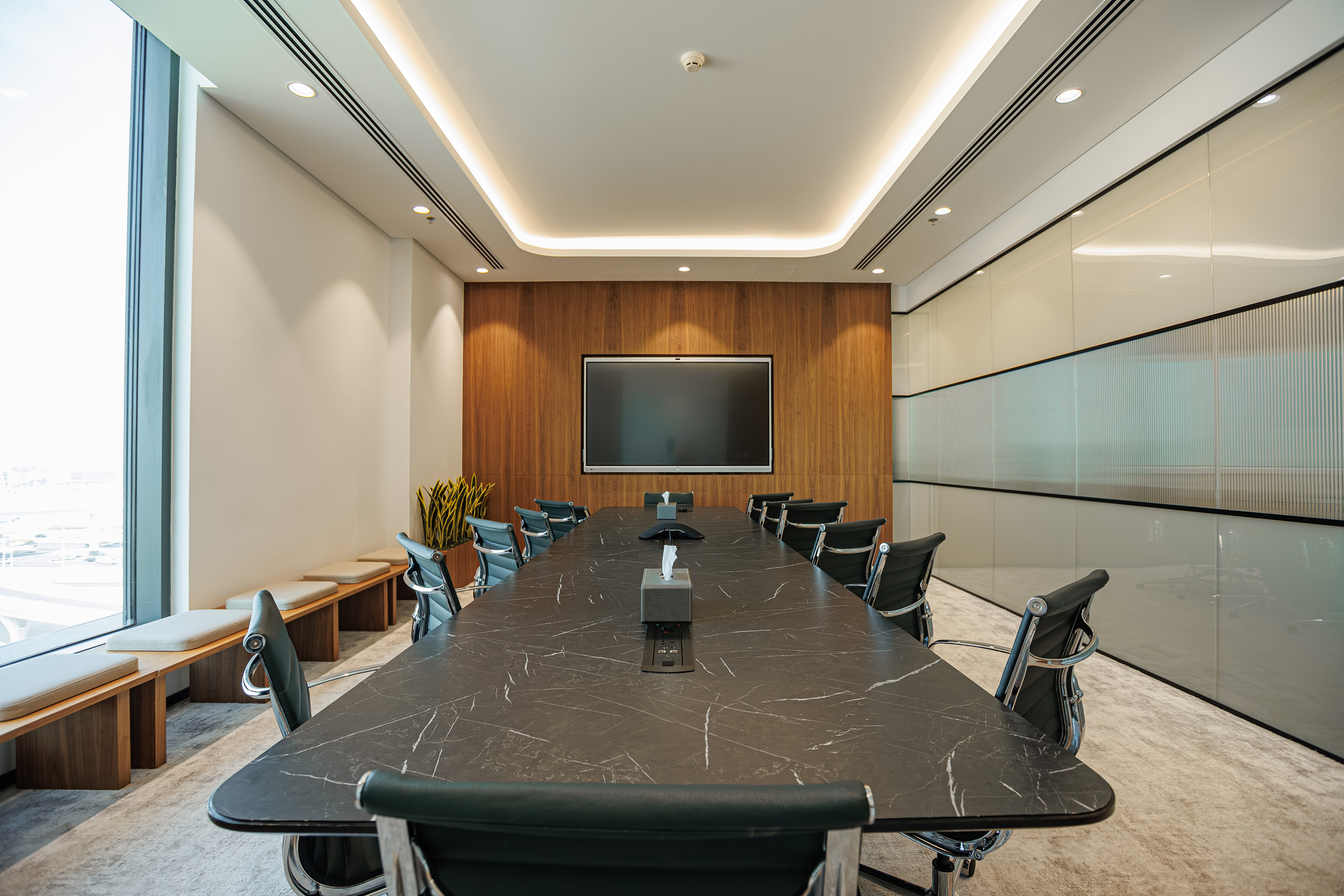 The boardroom at flowork Dubai Hills, marble table and smart-screen wall, the city beyond the glass