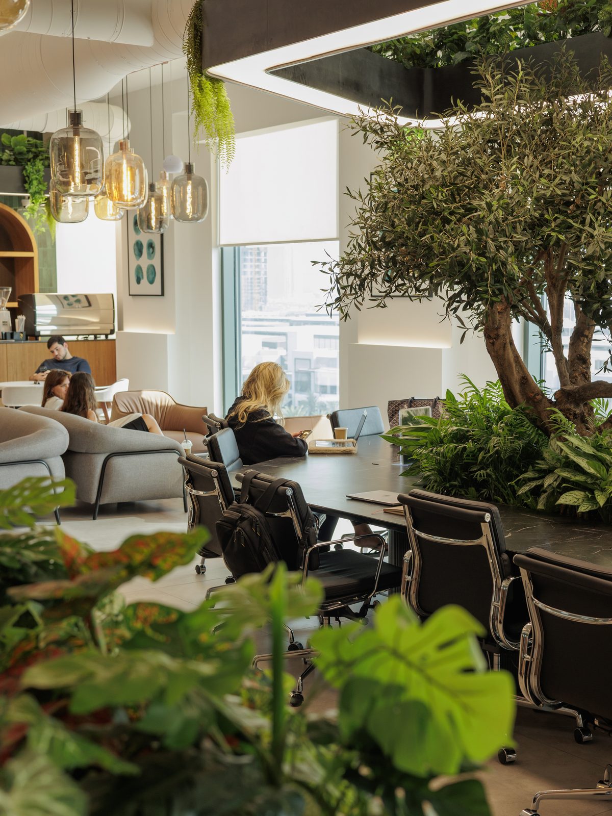 Members talking over coffee in the lounge at flowork Dubai Hills